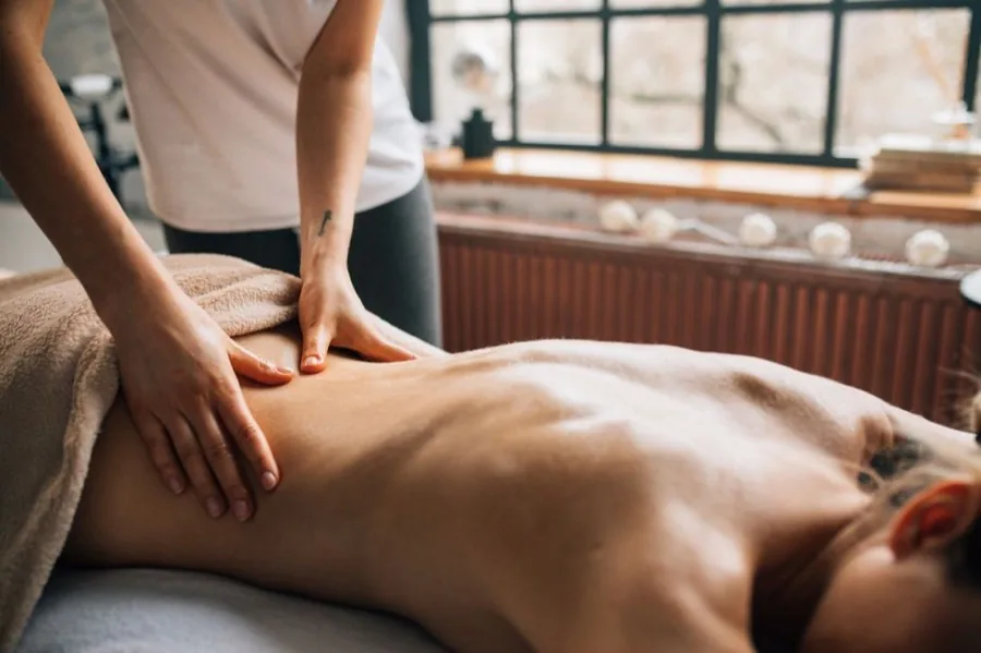 Registered massage therapist performing deep-tissue back treatment